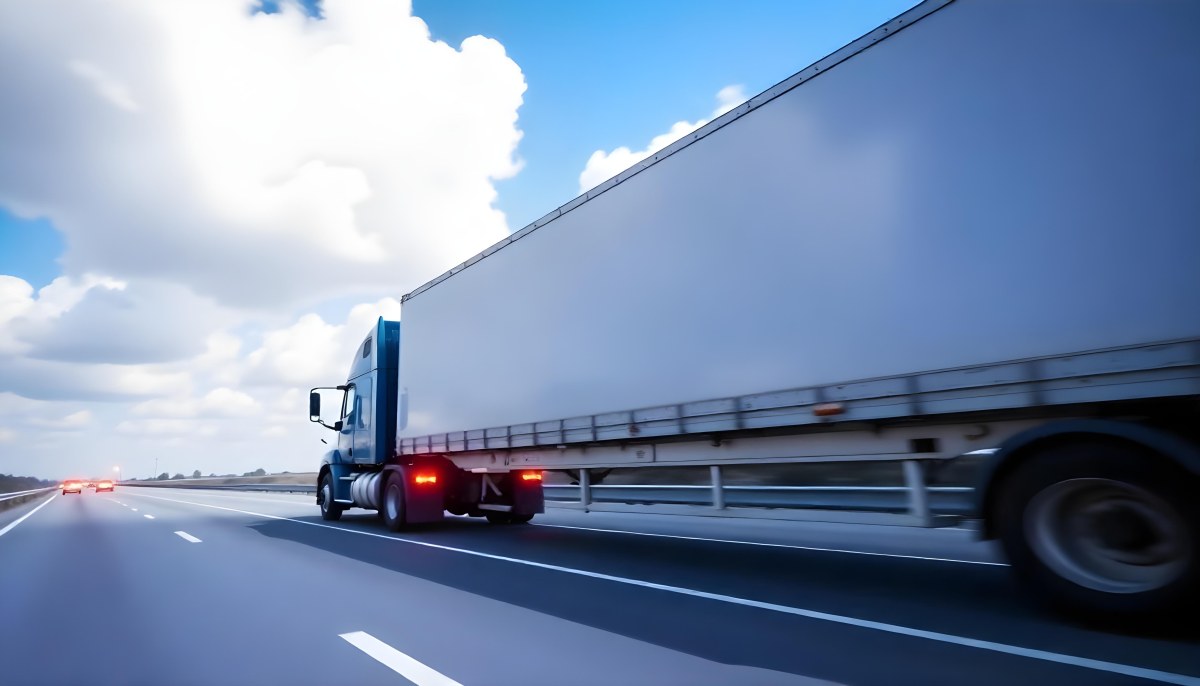 A Blue Semi Truck On A Highway With Motion Blur The Sky Is Black With Some Clouds Daytime 4 B2e3