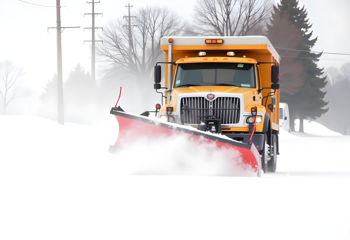 A Yellow Snowplow Truck Plowing Snow On A Road The Background Is A Snowy Landscape With Trees And Power Lines 6 E211