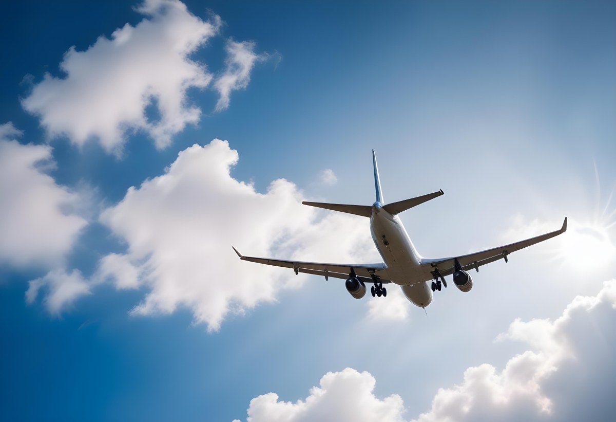 An Airplane Flying Against A Backdrop Of Blue Sky With Scattered Clouds The Aircraft Is Viewed From Below Showcasing Its Wings And Tail 9 1649