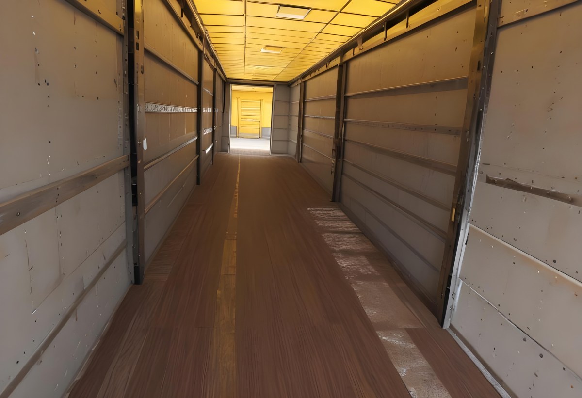 Inside Of An Empty Semi Truck Trailer With Brown Floor And Metal Walls Yellow Ceiling Wooden Door At The End 6 F4a1