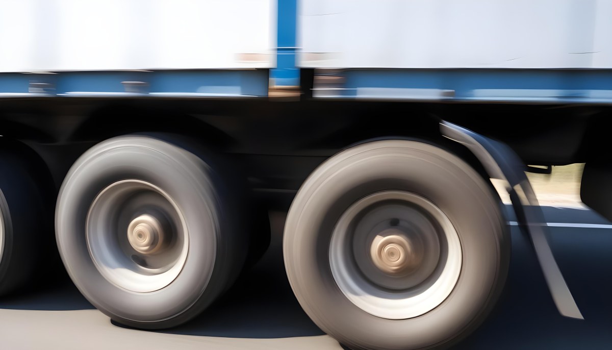 Truck Wheels In Motion Showing The Blur Of Movement With A Blue And White Truck Body Above On A Road 14 Fa99