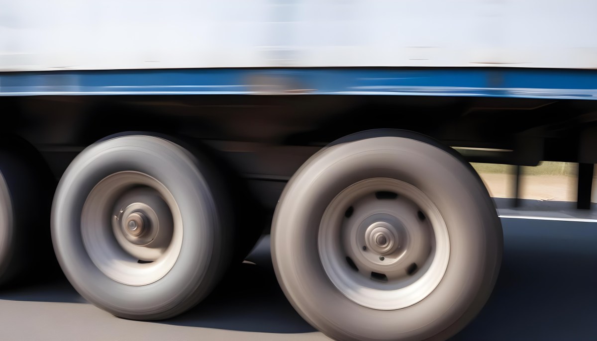 Truck Wheels In Motion Showing The Blur Of Movement With A Blue And White Truck Body Above On A Road 17 209f