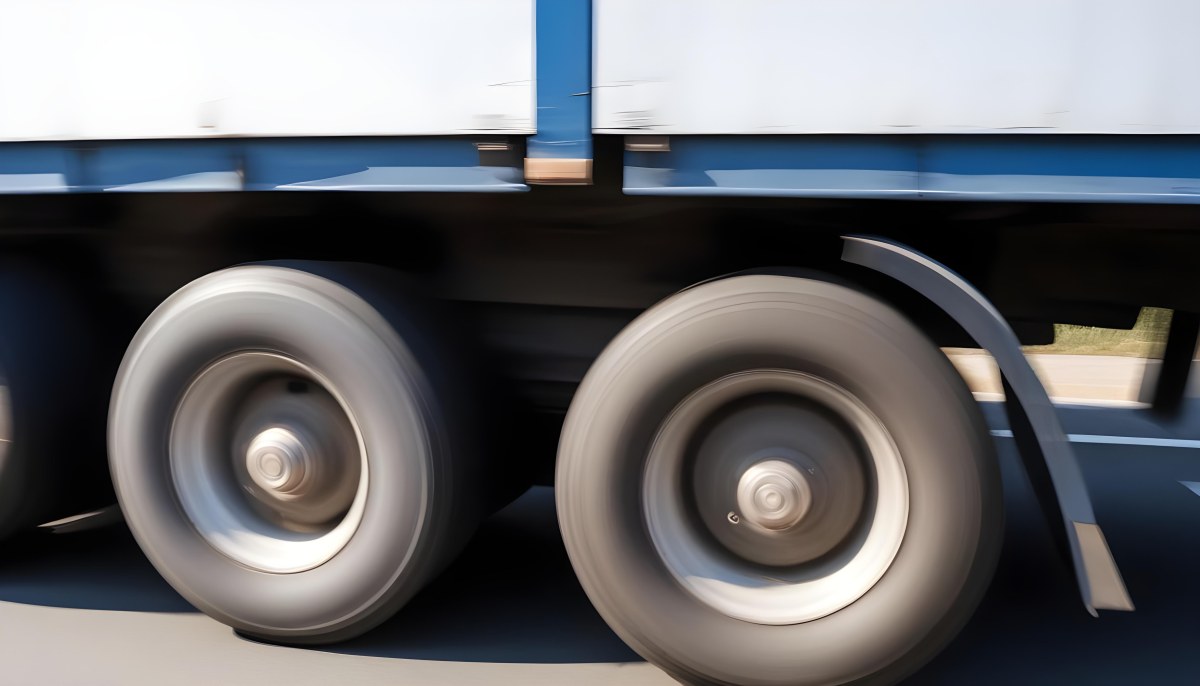 Truck Wheels In Motion Showing The Blur Of Movement With A Blue And White Truck Body Above On A Road 18 Ba87