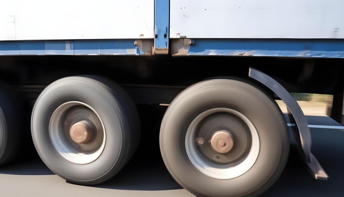 Truck Wheels In Motion Showing The Blur Of Movement With A Blue And White Truck Body Above On A Road 20 Efb8