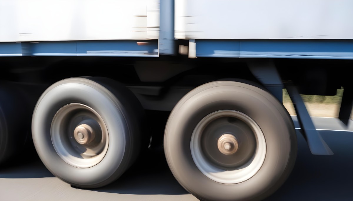 Truck Wheels In Motion Showing The Blur Of Movement With A Blue And White Truck Body Above On A Road 7 96da