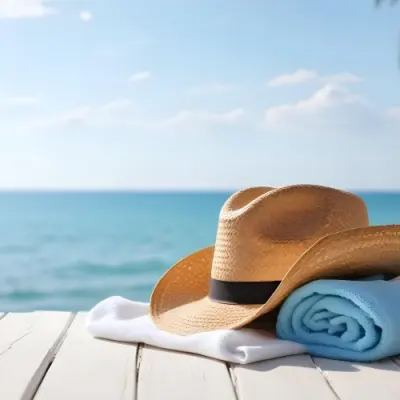 A Straw Hat And A White Towel On A White Wooden Table With A Blurred Background Of The Sea And The Sky 1 2c0a