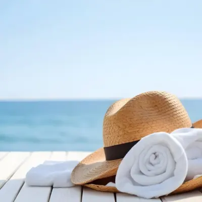 A Straw Hat And A White Towel On A White Wooden Table With A Blurred Background Of The Sea And The Sky 10 Bcc7
