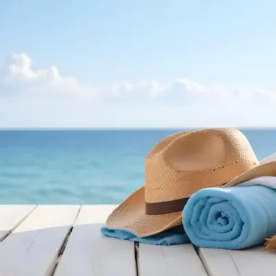 A Straw Hat And A White Towel On A White Wooden Table With A Blurred Background Of The Sea And The Sky 11 5fd5