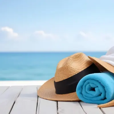 A Straw Hat And A White Towel On A White Wooden Table With A Blurred Background Of The Sea And The Sky 12 F5ab