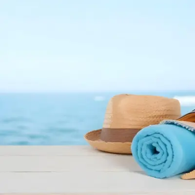 A Straw Hat And A White Towel On A White Wooden Table With A Blurred Background Of The Sea And The Sky 20 D820