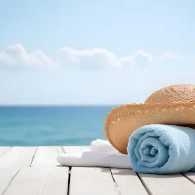 A Straw Hat And A White Towel On A White Wooden Table With A Blurred Background Of The Sea And The Sky 9 Ade6