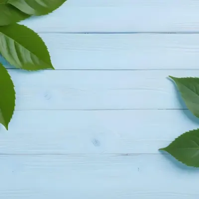 Green Leaves On A Light Blue Wooden Surface The Leaves Are Arranged In The Corners Of The Image The Background Is A Light Blue Color 12 0414