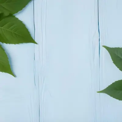 Green Leaves On A Light Blue Wooden Surface The Leaves Are Arranged In The Corners Of The Image The Background Is A Light Blue Color 17 A6be