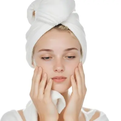 35mm Film Photography A Young Woman With Fair Skin And Short Blonde Hair Wearing A White Towel On Her Head Gently Washing Her Face With Her Hands In A Bright Bathroom High Detail 2 688c