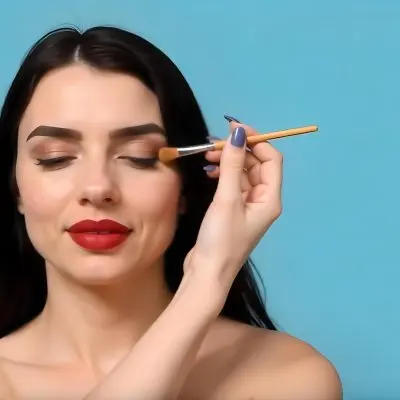 A 22 Year Old Hispanic Woman With Blue Hair Applying Makeup With A Brush Black Lipstick Closed Eyes In A Black Background 12 Ddab
