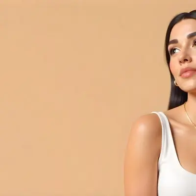 A 23 Year Old Hispanic Woman With Dark Skin Dark Hair Wearing A White Top And Jewelry Looking To The Right In A Beige Background 19 C1d9