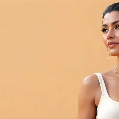 A 23 Year Old Hispanic Woman With Dark Skin Dark Hair Wearing A White Top And Jewelry Looking To The Right In A Beige Background 20 Dea3