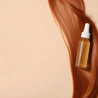 A Bottle Of Hair Serum On Top Of A Strand Of Long Straight Red Hair Beige Background 20 D9ec