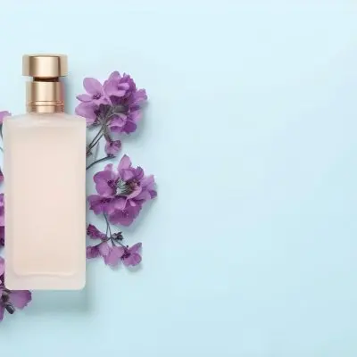 A Bottle Of Perfume With A Purple Cap Surrounded By Purple Flowers On A Light Blue Background 51 48d4