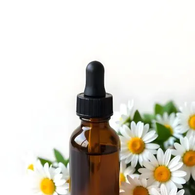 A Bottle Of Yellow Liquid Surrounded By White Daisy Flowers On A Light Background 28 755c