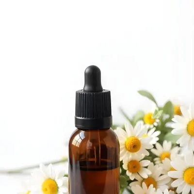 A Bottle Of Yellow Liquid Surrounded By White Daisy Flowers On A Light Background 32 E6a9