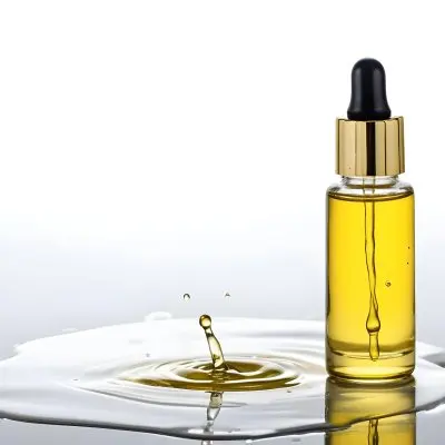 A Bottle Of Yellow Oil With A Dropper A Splash Of Oil On A White Surface And A White Background 19 Eb1d