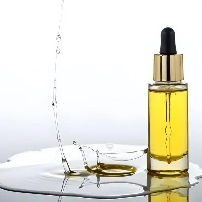 A Bottle Of Yellow Oil With A Dropper A Splash Of Oil On A White Surface And A White Background 21 6948