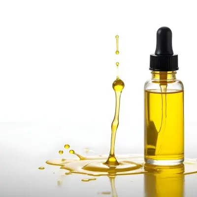 A Bottle Of Yellow Oil With A Dropper A Splash Of Oil On A White Surface And A White Background 3 1477