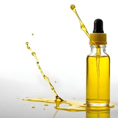 A Bottle Of Yellow Oil With A Dropper A Splash Of Oil On A White Surface And A White Background 7 328f