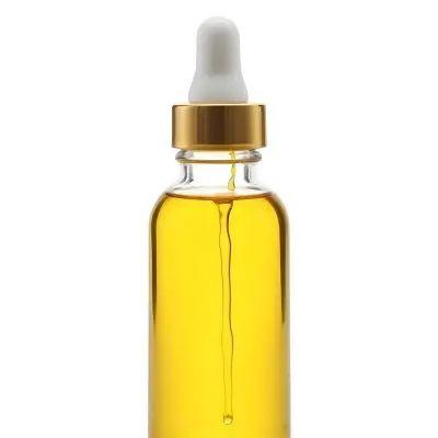 A Bottle With Yellow Oil And A Golden Dropper With A White Cap On A White Background 23 0aea