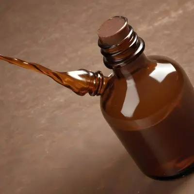 A Brown Glass Bottle With A Dropper On A Background Of Brown Hair The Hair Is Wavy And Shiny The Bottle Is In The Upper Right Corner 25 C893