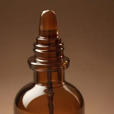 A Brown Glass Bottle With A Dropper On A Background Of Brown Hair The Hair Is Wavy And Shiny The Bottle Is In The Upper Right Corner 32 6403