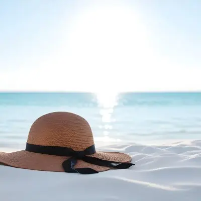 A Brown Sun Hat With A Ribbon On A White Sand Beach Turquoise Sea And Clear Sky In The Background 13 Bdca