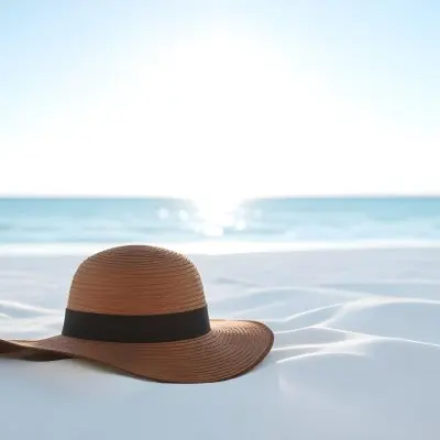 A Brown Sun Hat With A Ribbon On A White Sand Beach Turquoise Sea And Clear Sky In The Background 3