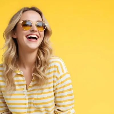 A Caucasian Woman 28 Years Old Blonde Wavy Hair Yellow Sunglasses And A Striped Shirt Laughing In A Yellow Background 22 3142
