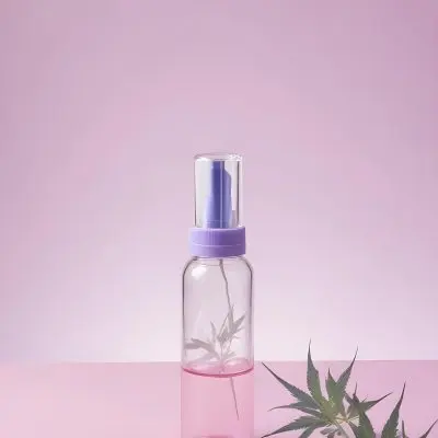 A Clear Glass Bottle With A Pink Cap Placed On A Pink Surface Cannabis Leaves In The Foreground Light Purple Background 36 B84c