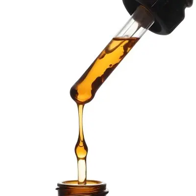 A Close Up Of A Dropper Filled With Amber Liquid Poised Above A Brown Glass Bottle Against A Stark White Background 2 A2be