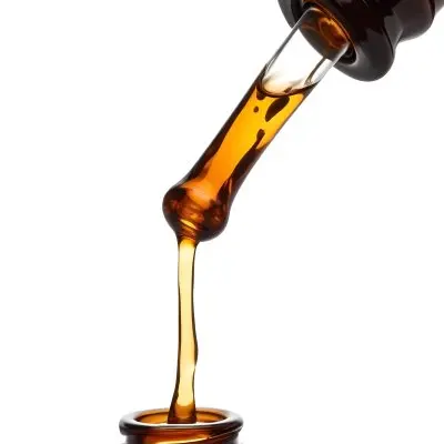 A Close Up Of A Dropper Filled With Amber Liquid Poised Above A Brown Glass Bottle Against A Stark White Background 3 8439