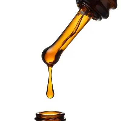 A Close Up Of A Dropper Filled With Amber Liquid Poised Above A Brown Glass Bottle Against A Stark White Background 4 2674