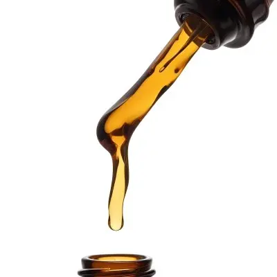 A Close Up Of A Dropper Filled With Amber Liquid Poised Above A Brown Glass Bottle Against A Stark White Background 5 Ea33