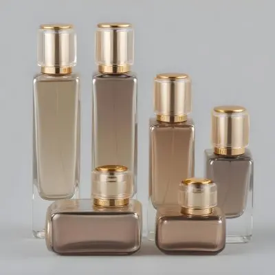 A Collection Of Luxury Glass Perfume Bottles With Gold Colored Caps And Accents Arranged On A Gray Background 11 0a70