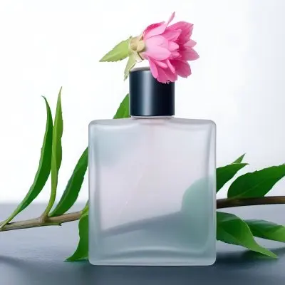 A Frosted Glass Perfume Bottle With A Pink Cap A Pink Flower On Top And Green Leaves Around It On A Glass Surface And Black Background 25 Ff31