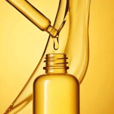 A Glass Bottle Filled With Golden Colored Olive Oil Against A Bright Yellow Background 13