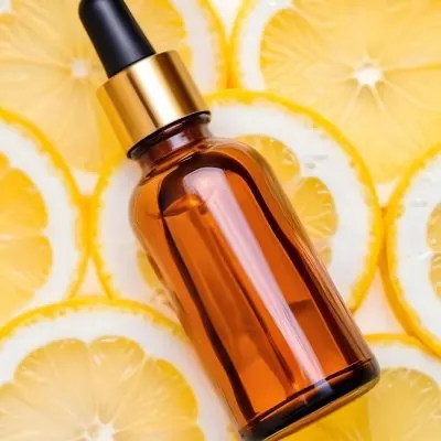 A Glass Bottle Of Orange Juice With Fresh Orange Slices And Whole Lemons In The Background 6 7398