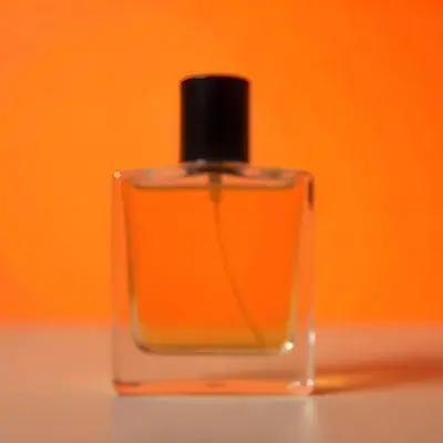 A Glass Bottle Of Perfume Or Cologne On An Orange Background 31 7927