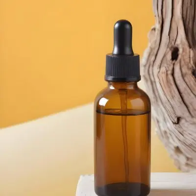 A Glass Bottle With A Dropper Cap Filled With Amber Colored Liquid Placed On A White Surface Against A Yellow Background 4