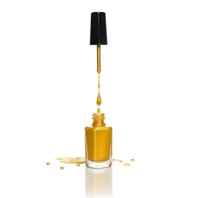 A Golden Nail Polish Bottle With A Drop Falling Into It And The Brush Above It On A White Background 45 Effa