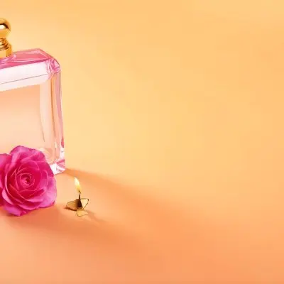 A Golden Perfume Bottle With A Pink Cap And A Golden Candle Holder On A Pink Background 3 9682