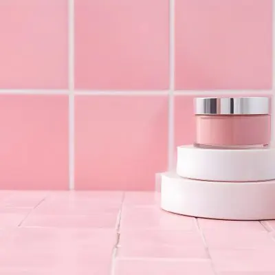 A Jar Of Makeup On Top Of Three White Platforms In A Pink Tiled Bathroom The Background Is Pink Tiles And The Floor Is White 13 97b8