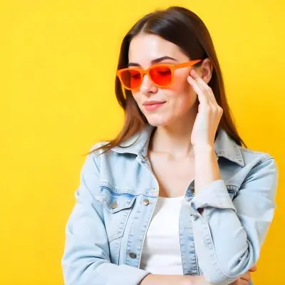 A Middle Eastern Woman Age 22 With Brown Hair And Orange Sunglasses Wearing A Denim Jacket With A Yellow Background 28 82ca